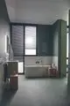 Ein Badezimmer mit einer Dusche und freistehender Badewanne. Die Wände sind in sanften Farben gestrichen, und eine Handbrause von Ideal Standard ist sichtbare. Helle Fliesen und Fenster bieten Tageslicht.